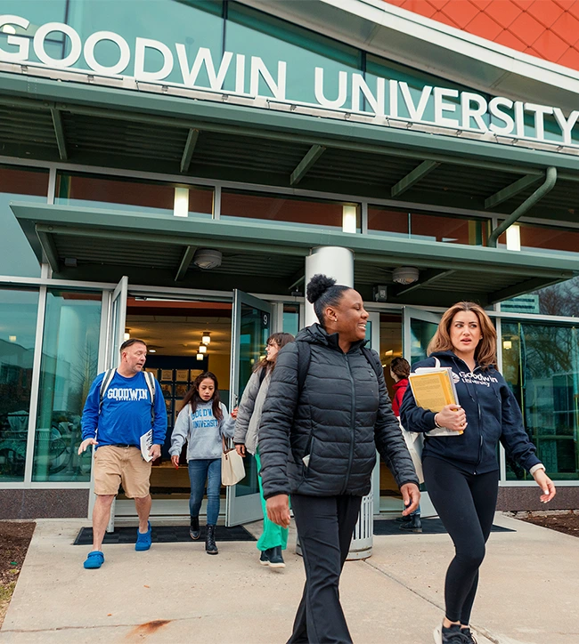 Students exiting the Goodwin University building entrance and walking outside