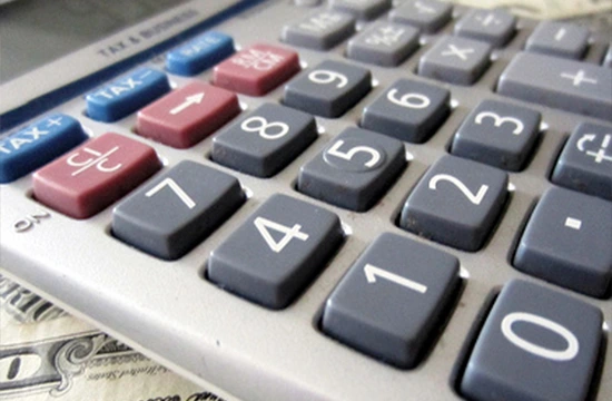 Close-up of a calculator keypad with U.S. currency in the background