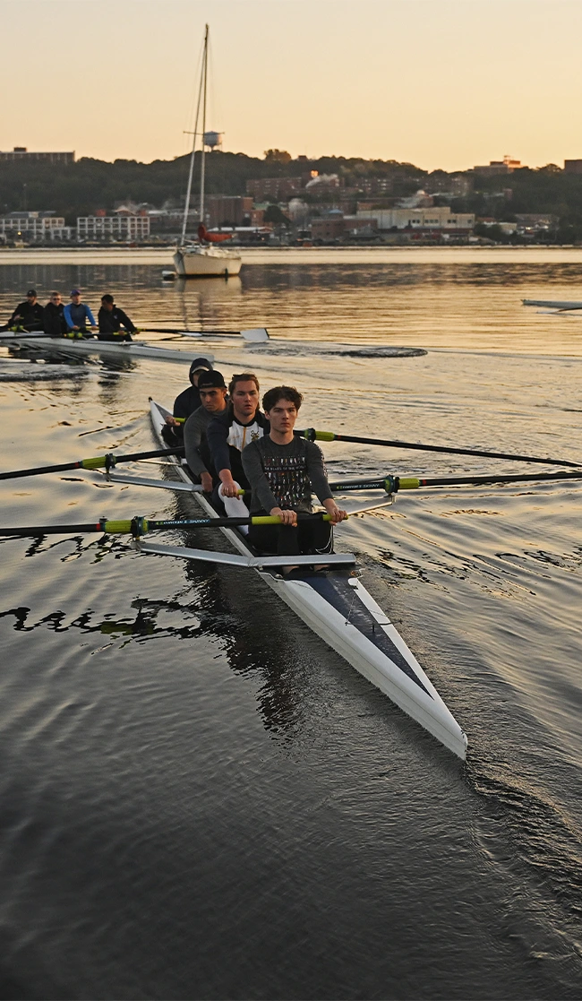 Rowing team practicing on a river at sunrise